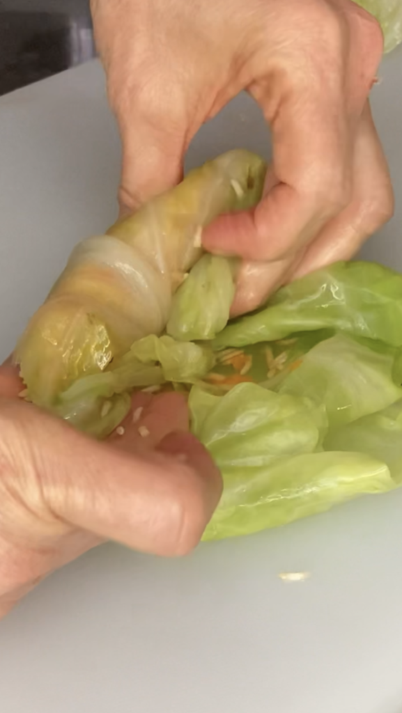 Roll leaf up once, then fold side flaps towards middle and tuck under roll up.