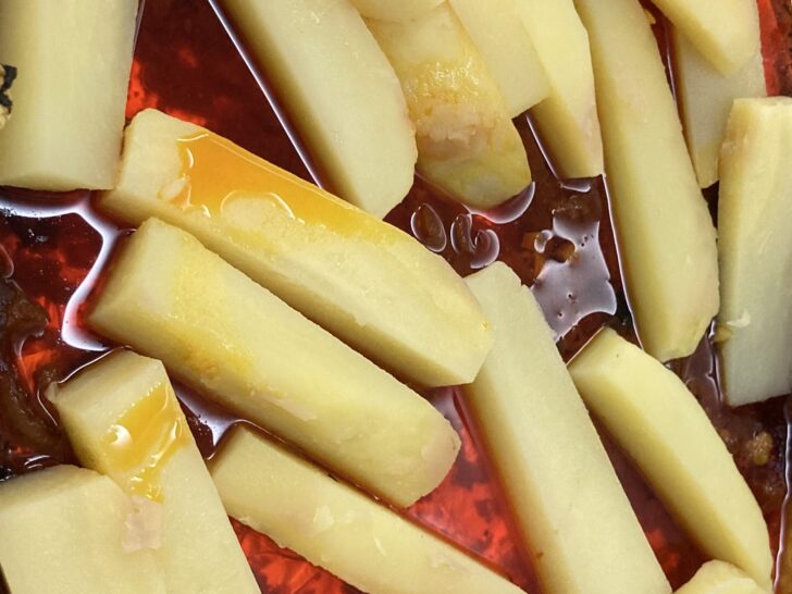 raw potato wedges/logs lying in pre-baked chicken gravy,