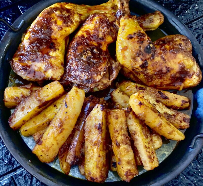 Displaying chicken and potatoes baked in its gravy Baked chicken and potato wedges on serving plate