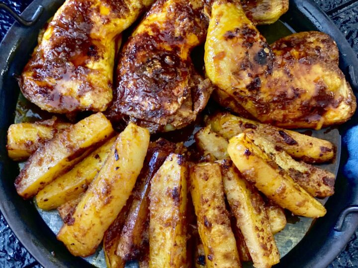 Baked chicken and potatoes on serving plate