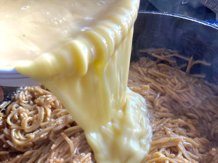 Caramelized Noodle Kugel - pouring eggs into cooked noodles