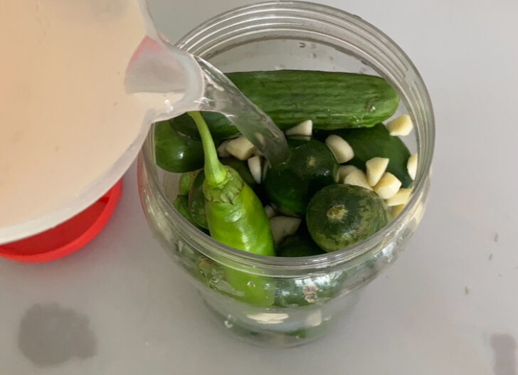 Adding water to cucumbers to make pickles