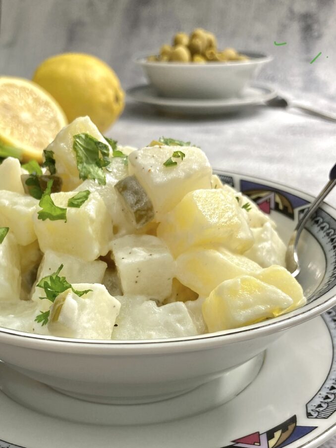Classic Israeli Potato Salad with dill pickles in a bowl ready to be eaten